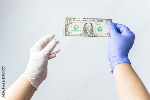blue latex gloved hand holding dollar bill. Concept financial crisis coronavirus, covid-19