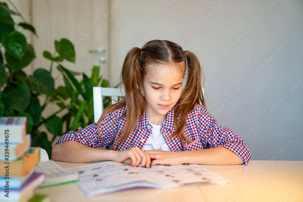 schoolgirl in a plaid shirt studying at home schoolgirl in a plaid shirt studying at home