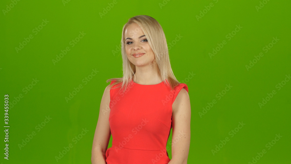 Blond girl in red dress posing in front of camera Blond girl in red dress posing in front of camera