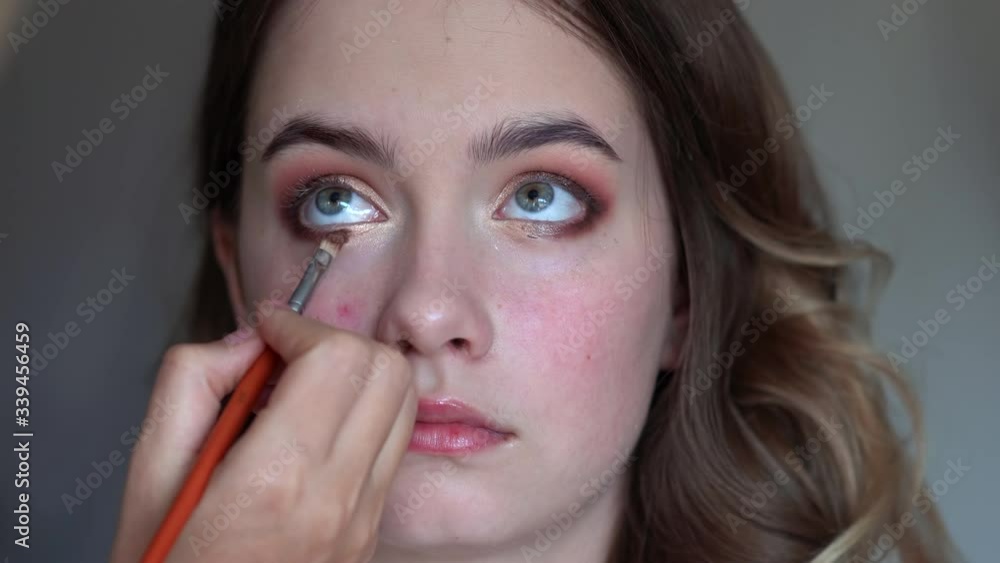 Girl makeup artist paints the eyes of a young girl Girl makeup artist paints the eyes of a young girl