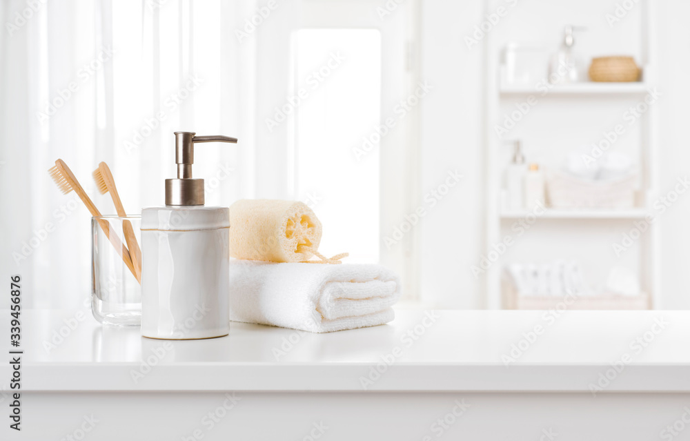 Soap dispenser, toothbrushes and white towel on bathroom counter interior Soap dispenser, toothbrushes and white towel on bathroom counter interior