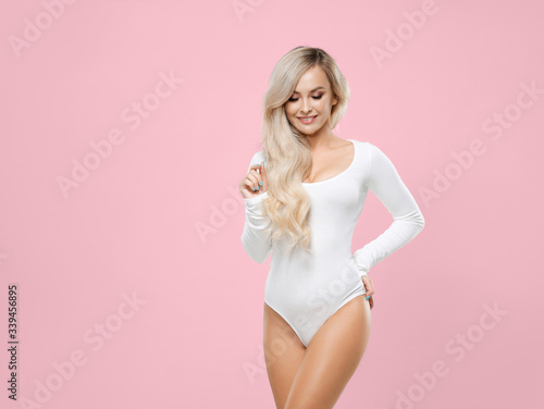 Young and sporty blond girl posing in sexy swimsuit. Beautiful and healthy woman in studio. Fitness, health care, nutrition and diet.
