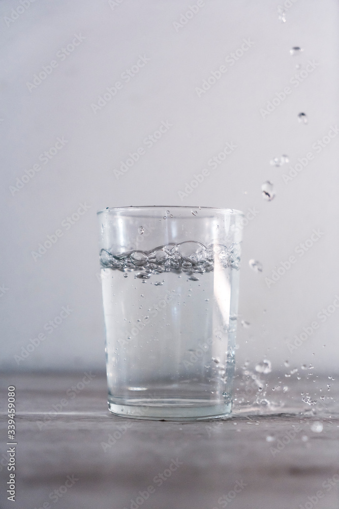 Large drops of water from above into a glass of water. Drink macro photography Large drops of water from above into a glass of water. Drink macro photography
