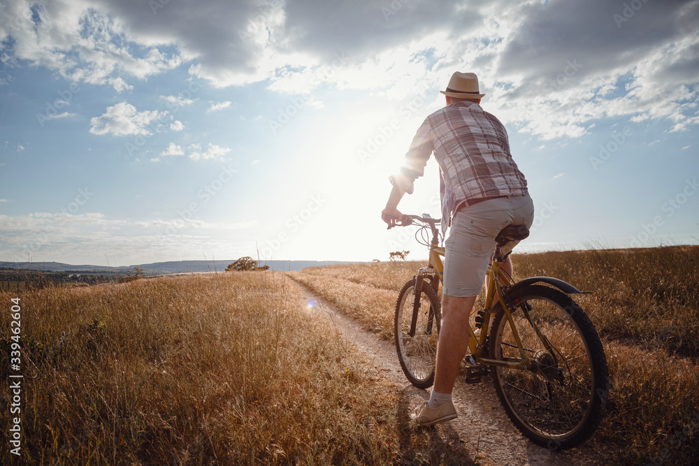 Fototapeta premium young attractive man traveling on bicycle on summer vacation