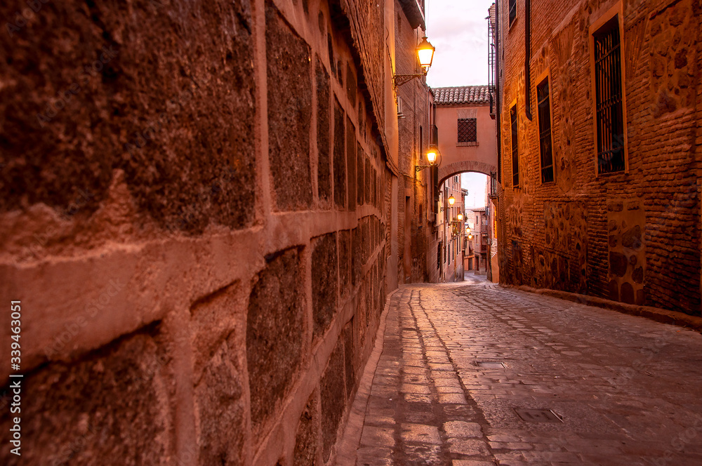 View of the old streets in Toledo, Spain. Quiet stone pavemented street. Medieval cobbled city.