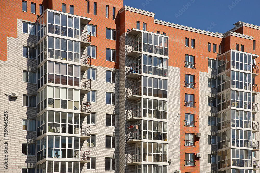 Lviv, Ukraine - 3 4 2020: Facade of a tall multi-storey modern house with balconies and large glass windows. Design of modern architecture. Top view from the bottom. Modern city architecture