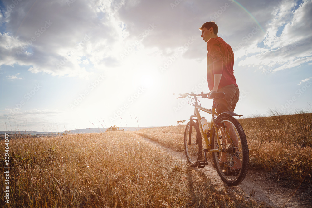 handsome man traveling with bicycle in sunset, healthy active lifestyle traveler