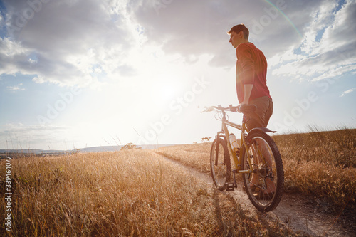 Fototapeta Naklejka Na Ścianę i Meble -  handsome man traveling with bicycle in sunset, healthy active lifestyle traveler