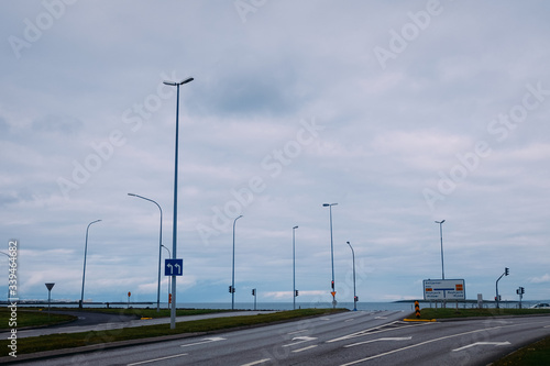 gray road crossroad with lines of lanterns on the ocean in reykjavik iceland in summer © dobrovizcki