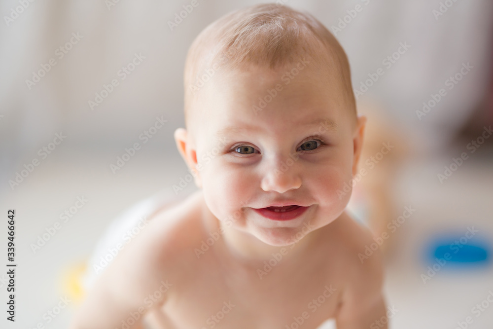 Happy smiling baby girl in sunny light. Positive emotion in morning. Front view. Closeup. Happy smiling baby girl in sunny light. Positive emotion in morning. Front view. Closeup.