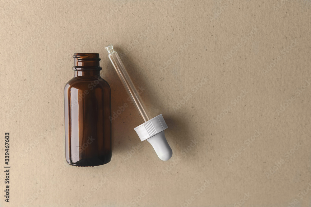 Top down view empty facial skincare product dark brown open serum glass bottle with uv protective packaging on brown organic paper background. healthcare concept Top down view empty facial skincare product dark brown open serum glass bottle with uv protective packaging on brown organic paper background. healthcare concept