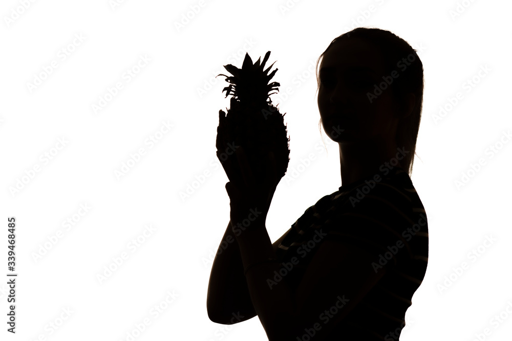 silhouette of woman figure with pineapple fruit in hands on white isolated background, concept vitamins and healthy food, female beauty and vegetarianism