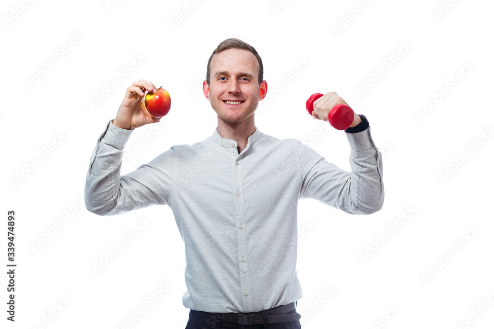 Caucasian male businessman holding a red-yellow apple and red dumbbell. He is wearing a shirt. Emotional portrait. Isolated on white background Caucasian male businessman holding a red-yellow apple and red dumbbell. He is wearing a shirt. Emotional portrait. Isolated on white background