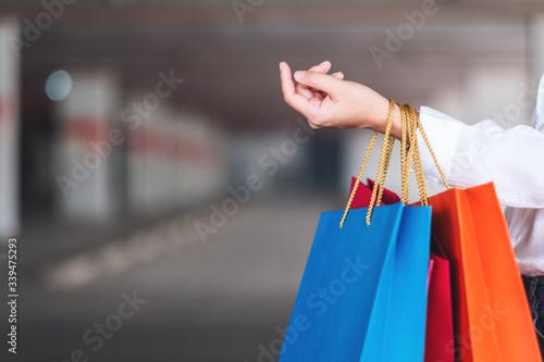 Closeup image of a woman holding shopping bags in the mall parking lot