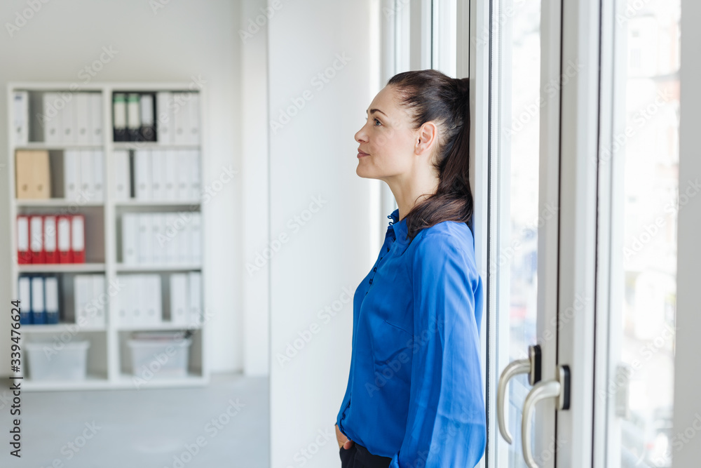 Woman leaning back on office windows Woman leaning back on office windows