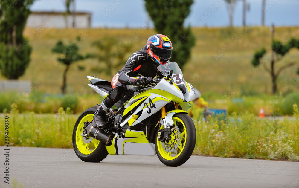 Motorcycle practice leaning into a fast corner on track Motorcycle practice leaning into a fast corner on track