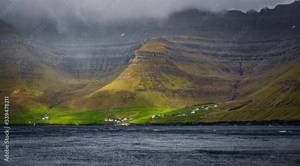 Very small village of Kunoy in Faroe Islands fjord