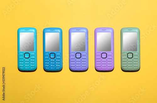 Five different colors of mobile phones in a line