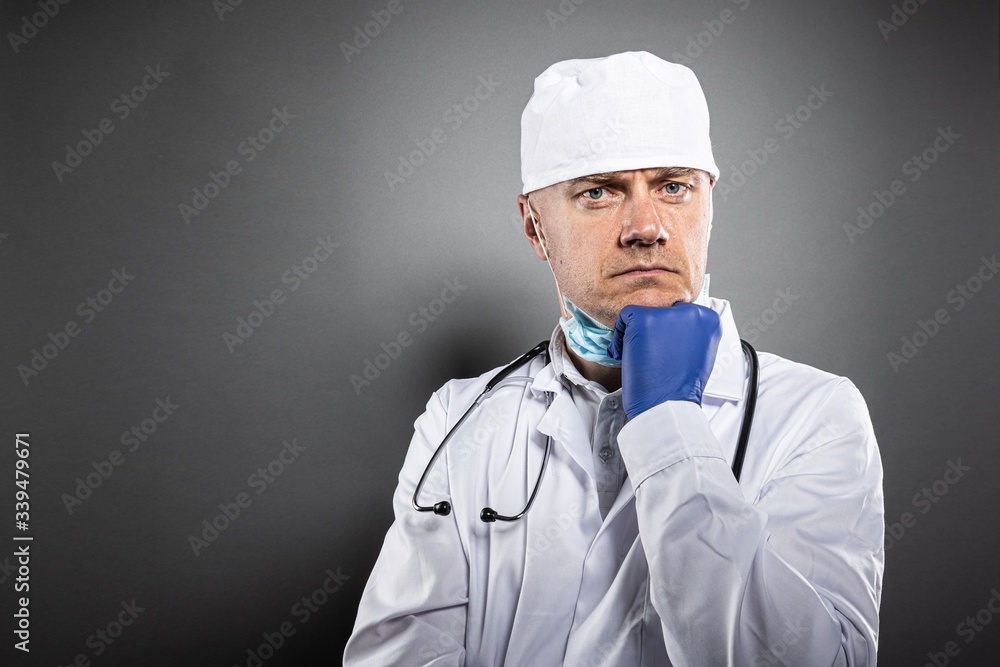 Thoughtful doctor in white uniform and protective gloves Thoughtful doctor in white uniform and protective gloves