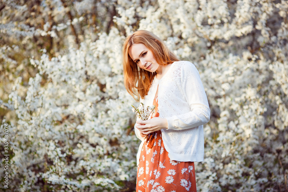 female in flowering shrub with branches in hands female in flowering shrub with branches in hands