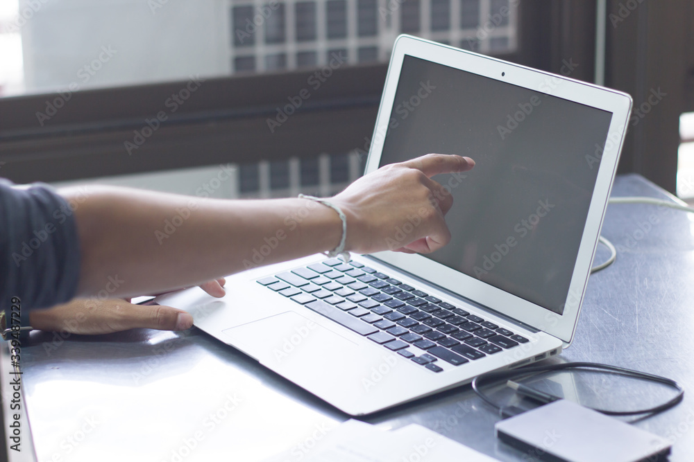 Hands businessman Pointing at the notebook screen, working at home Through the internet network Hands businessman Pointing at the notebook screen, working at home Through the internet network