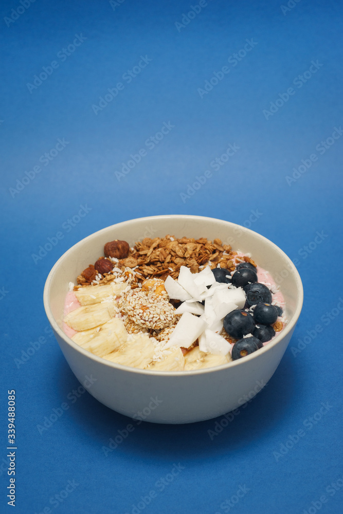 Handmade Bowl healthy tasty breakfast of yogurt, smoothie with granola, nuts, bananas and berries Handmade Bowl healthy tasty breakfast of yogurt, smoothie with granola, nuts, bananas and berries