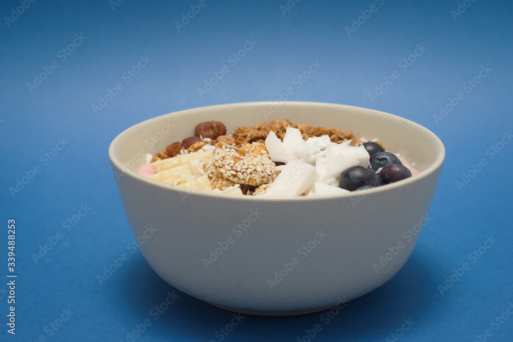 Handmade Bowl healthy tasty breakfast of yogurt, smoothie with granola, nuts, bananas and berries Handmade Bowl healthy tasty breakfast of yogurt, smoothie with granola, nuts, bananas and berries