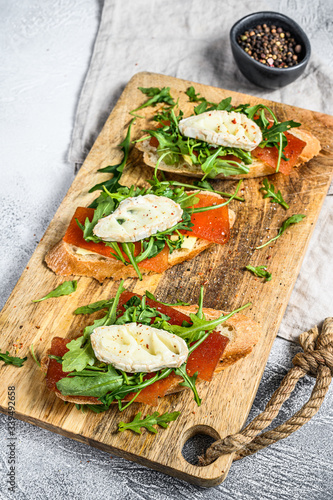 bruschetta with goat cheese, arugula and pear marmalade. Gray background. Top view