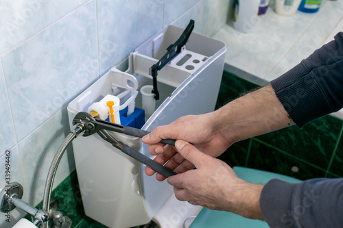 Tableau sur toile Plumber fixing a flush cistern.