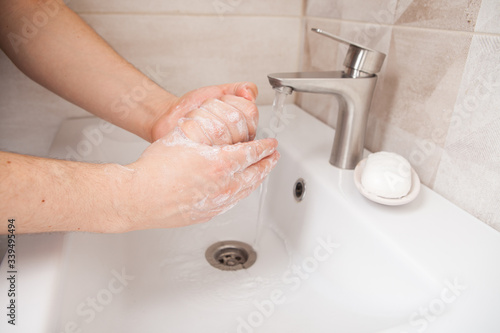 woman picks up liquid soap in her hands to wash. hand washing as protection against coronavirus infection.