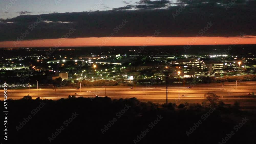 Brightly lighted businesses along the nearly deserted interstate during sunset near Weston Florida, aerial slide left Brightly lighted businesses along the nearly deserted interstate during sunset near Weston Florida, aerial slide left