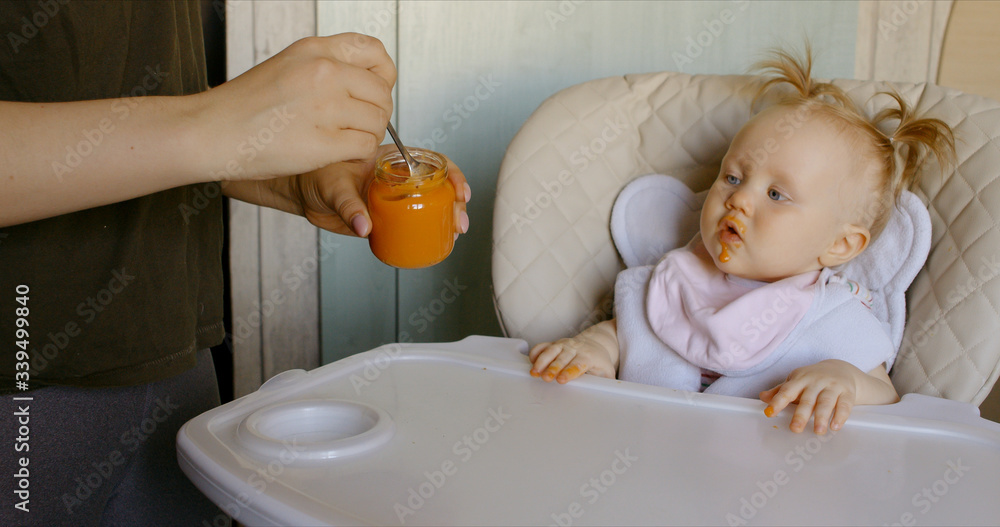 Caucasian mother feeding baby with spoon Caucasian mother feeding baby with spoon