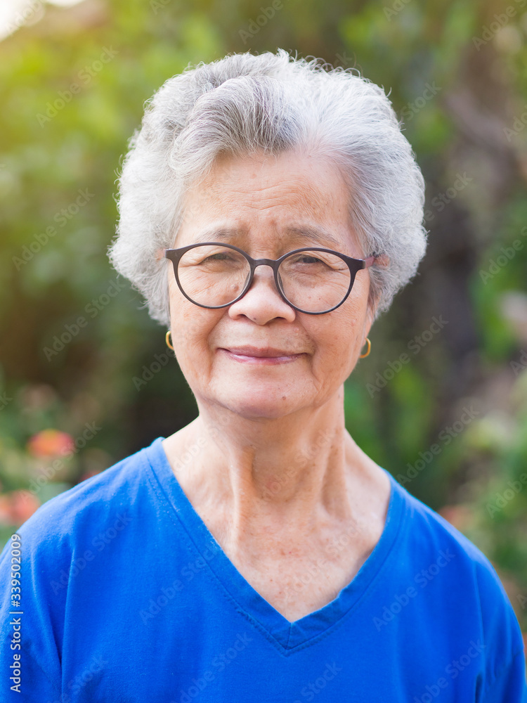 Portrait of elderly woman with short white hair standing smile and looking  at the camera in