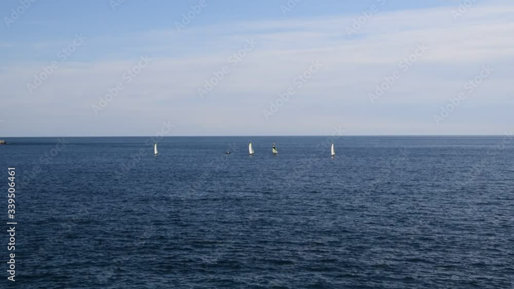 Blue sea sky and horizon with distant sailboats Blue sea sky and horizon with distant sailboats