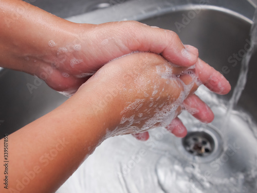 
Image of a man washing his hands with soap to prevent corona virus.