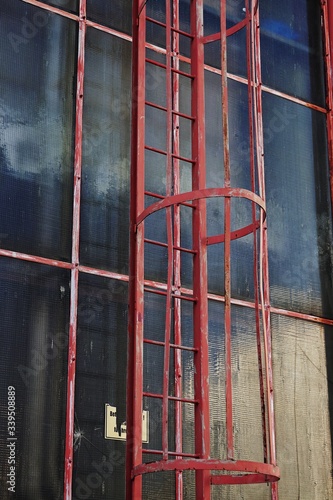 Obraz na płótnie Red fire ladder on a glass facade w salonie