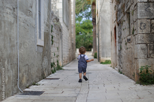 young boy is running on the street © chudachka