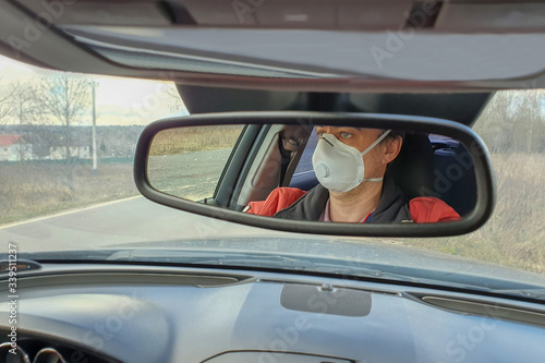 A man drives a car in a protective mask during an epidemic © сергей назаров
