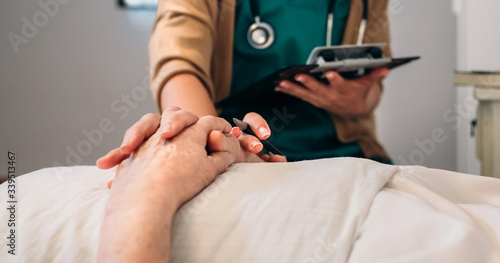 Female doctor comforting older patient
