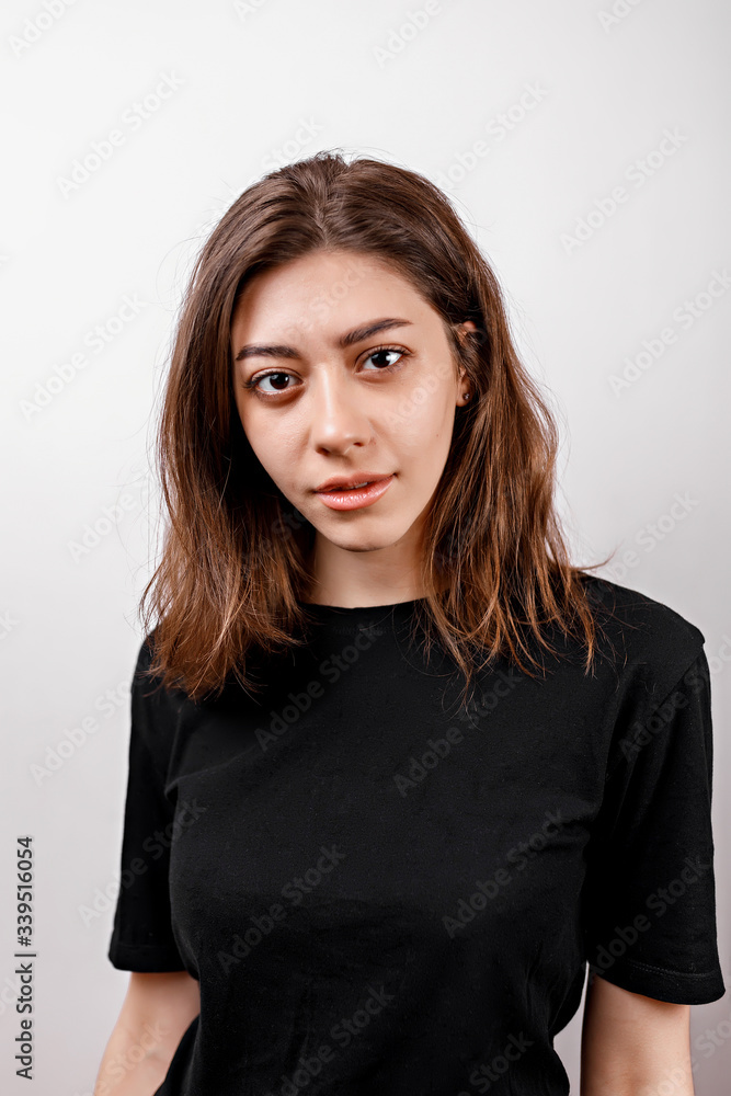Sad brunette woman looks upset at the camera on a white background isolated Sad brunette woman looks upset at the camera on a white background isolated