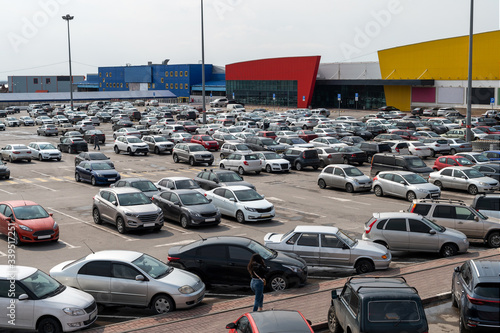 full parking at the supermarket on a cloudy afternoon. area with different supermarket and hypermarkets and warehouses