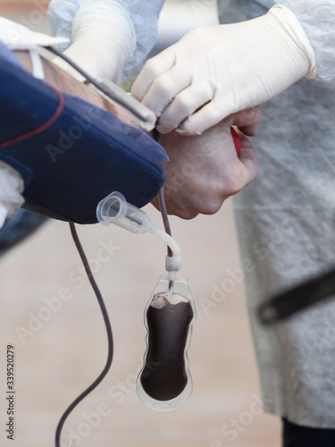 Donor donates blood from a vein in the presence of a doctor