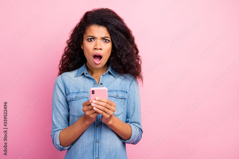 Portrait of amazed social media lover addicted afro american girl blogger use smart phone get dislike scream unbelievable feel impressed wear denim outfit isolated pink color background Portrait of amazed social media lover addicted afro american girl blogger use smart phone get dislike scream unbelievable feel impressed wear denim outfit isolated pink color background