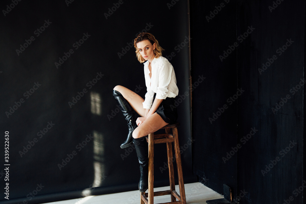 Portrait of a beautiful fashionable blonde woman in black shorts and white shirt Portrait of a beautiful fashionable blonde woman in black shorts and white shirt