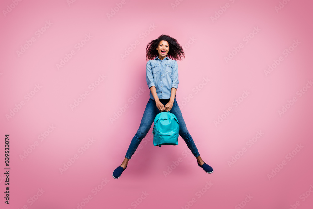 Full body photo of excited funky afro american girl rest relax after college study hold bag wear casual style sneakers isolated over pink color background