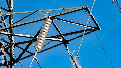 Canvas Print Electricity pylon insulator hanging from a towers crossbeam