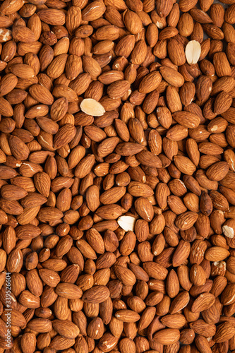 Background of large raw peeled almonds placed arbitrarily
