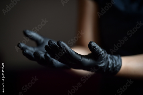 Indoors photo with unrecognizable person wearing black latex medical gloves in times of coronavirus pandemic © roibu