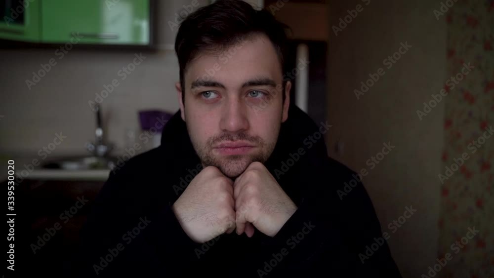 Young man looking straight in camera and grinning, propping up face with hands Young man looking straight in camera and grinning, propping up face with hands