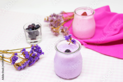 Blueberry and strawberry jelly mousse in glass cups with pink and purple dry flowers